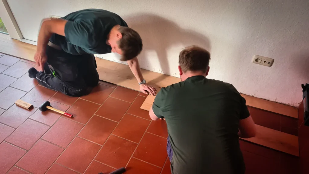 Zwei Männer verlegen Pakettboden